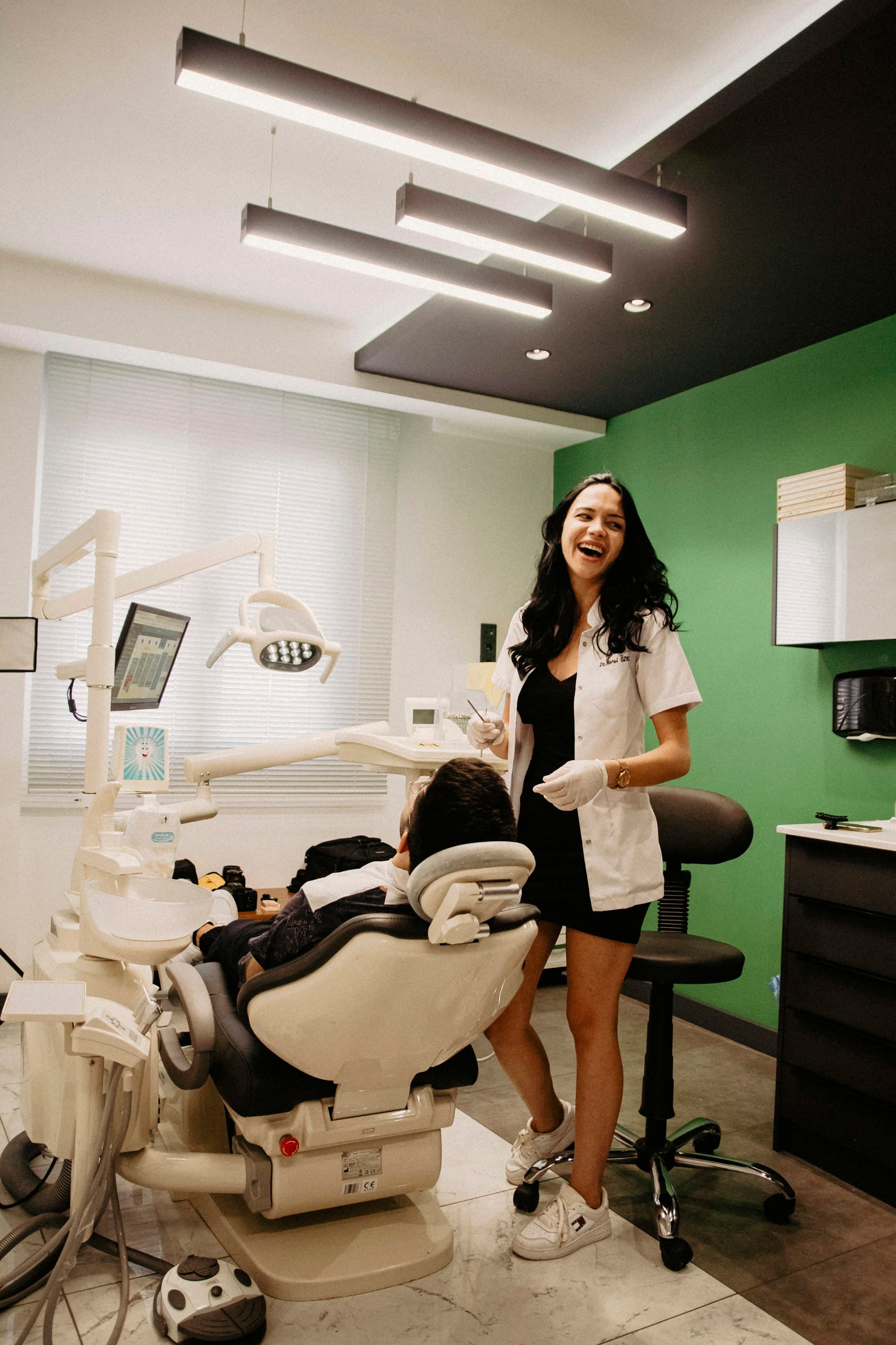 A dentist smiling with a patient in the chair.